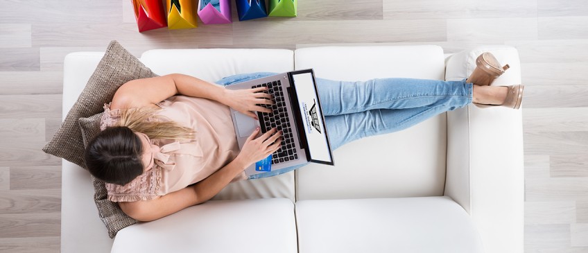 Ratgeber Online-Shopping - Frau liegt mit Laptop auf Sofa